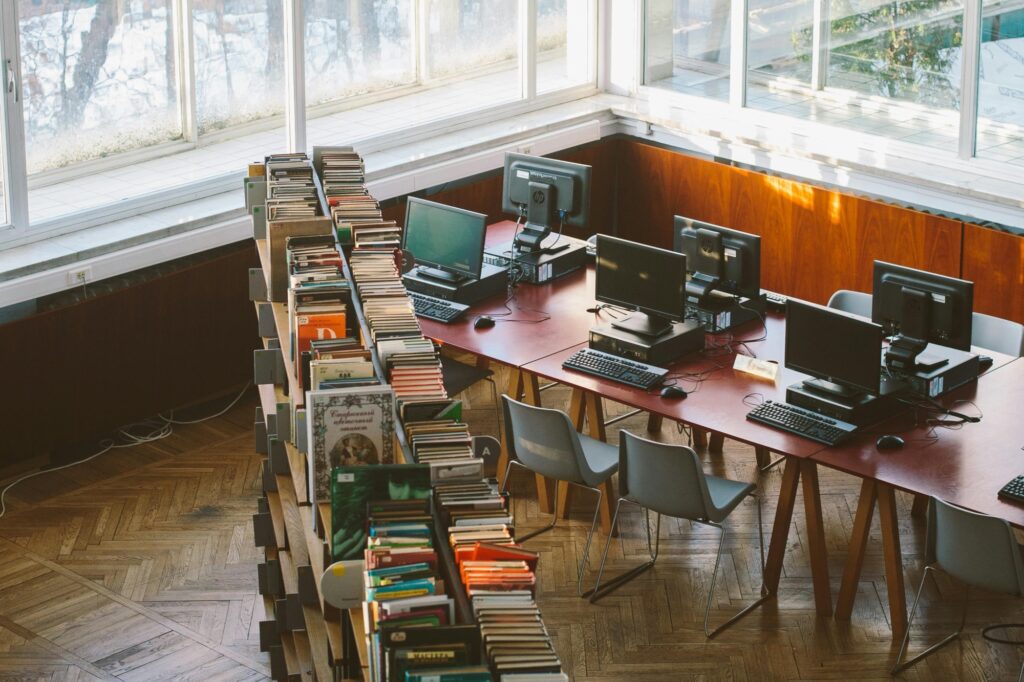An empty library filled with bookshelves and computers on the long table