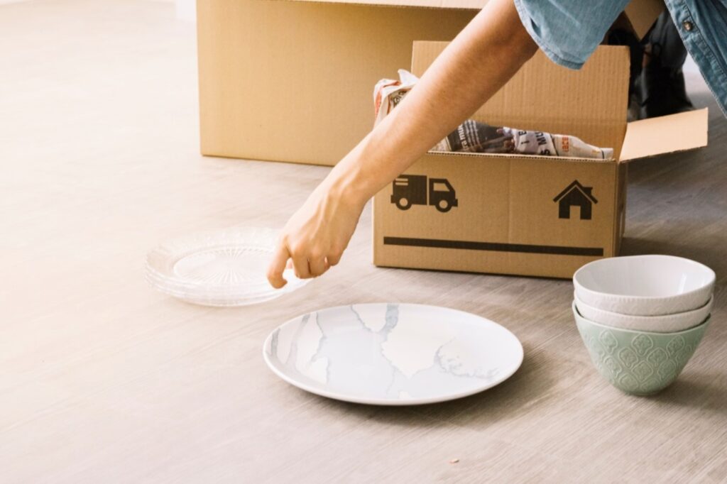 A woman unpacking dishes on the table